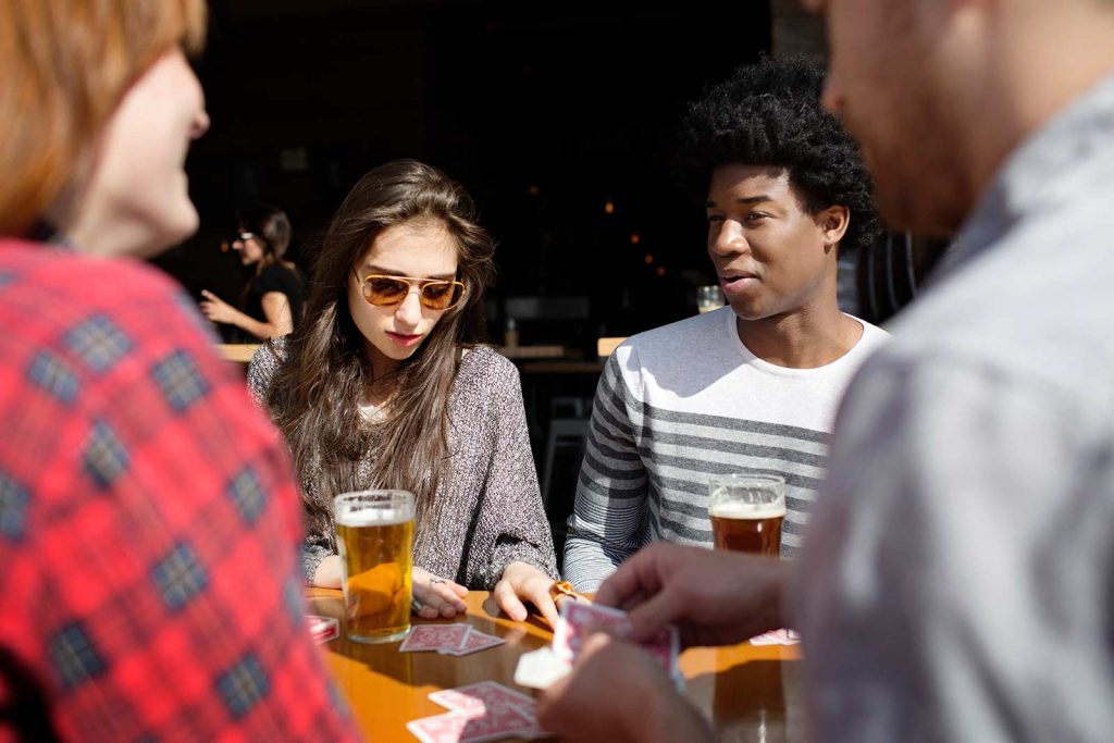 Friends playing cards at a bar