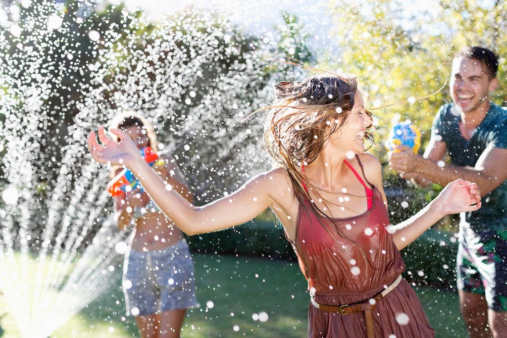 Friends partying in the front yard with a sprinkler